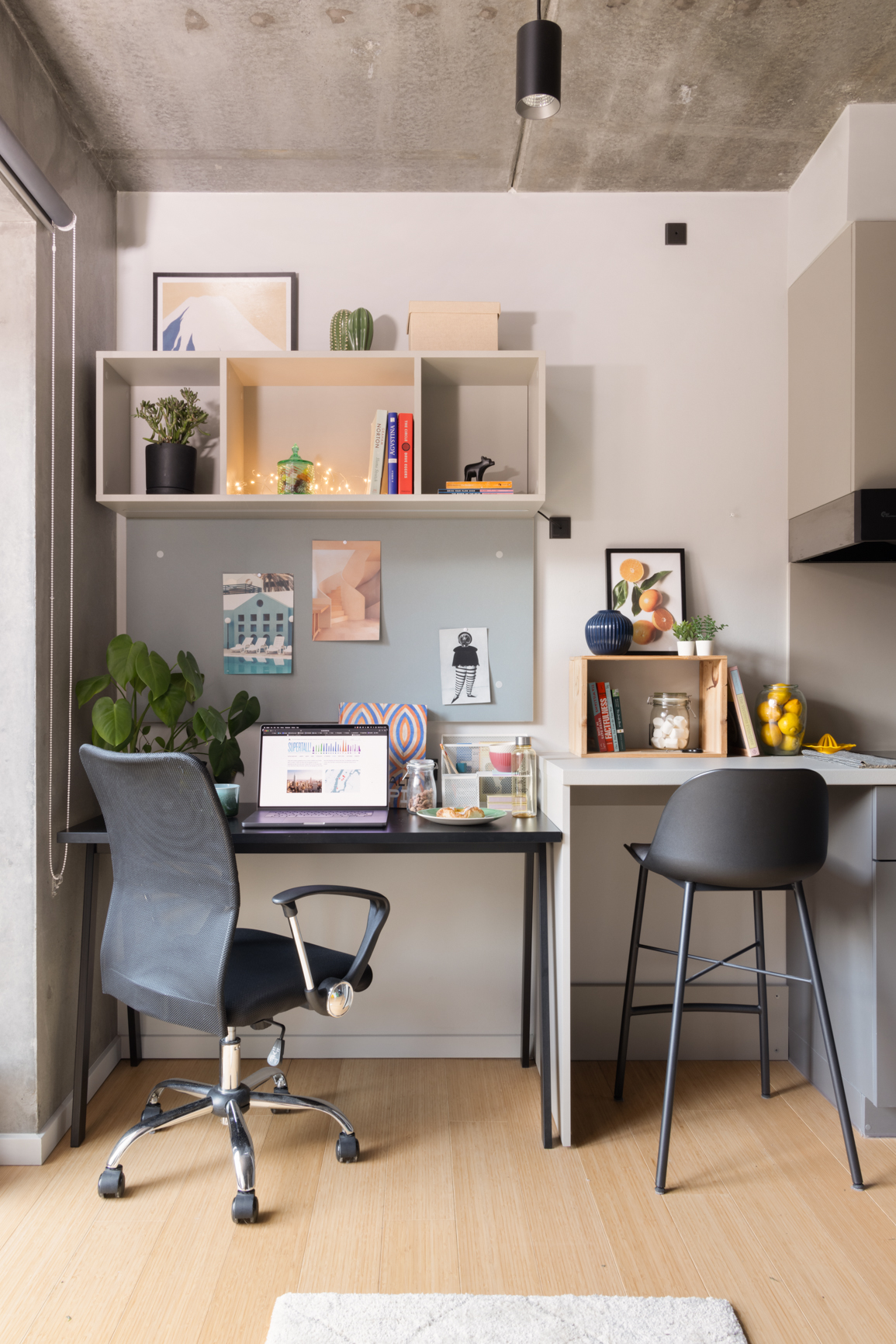 The Small but Mighty Studio, image showing mini kitchen with breakfast bar and desk with chair and shelving in Basestack Living student accommodation and apartments to rent in Copenhagen