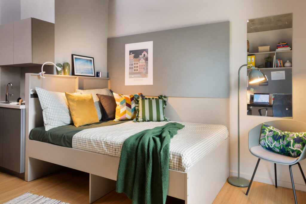 Modern Medium Studio with 140cm bed and mirror showing desk with chair at Basestack Living student accommodation and apartments to rent in Copenhagen