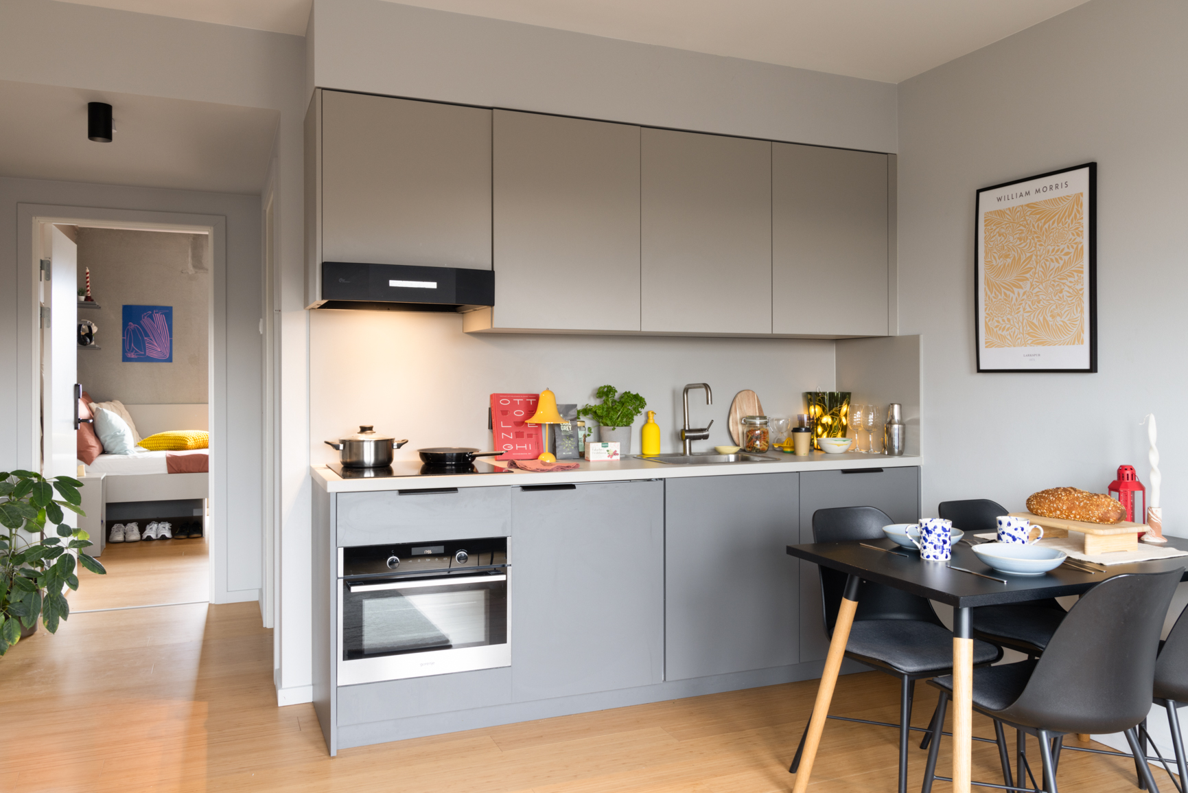 The Modern Medium 1 Bed Apartment open plan living room with kitchen and dining table with 4 chairs at Basestack Living student accommodation and apartments to rent in Copenhagen