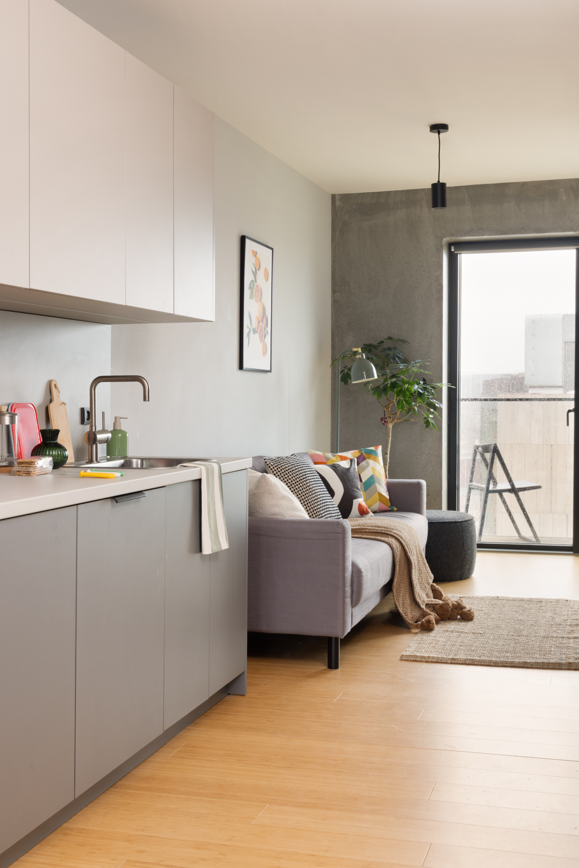 Big and Bold Apartment living area with sofa, balcony and mini kitchen at Basestack Living student accommodation and apartments to rent in Copenhagen