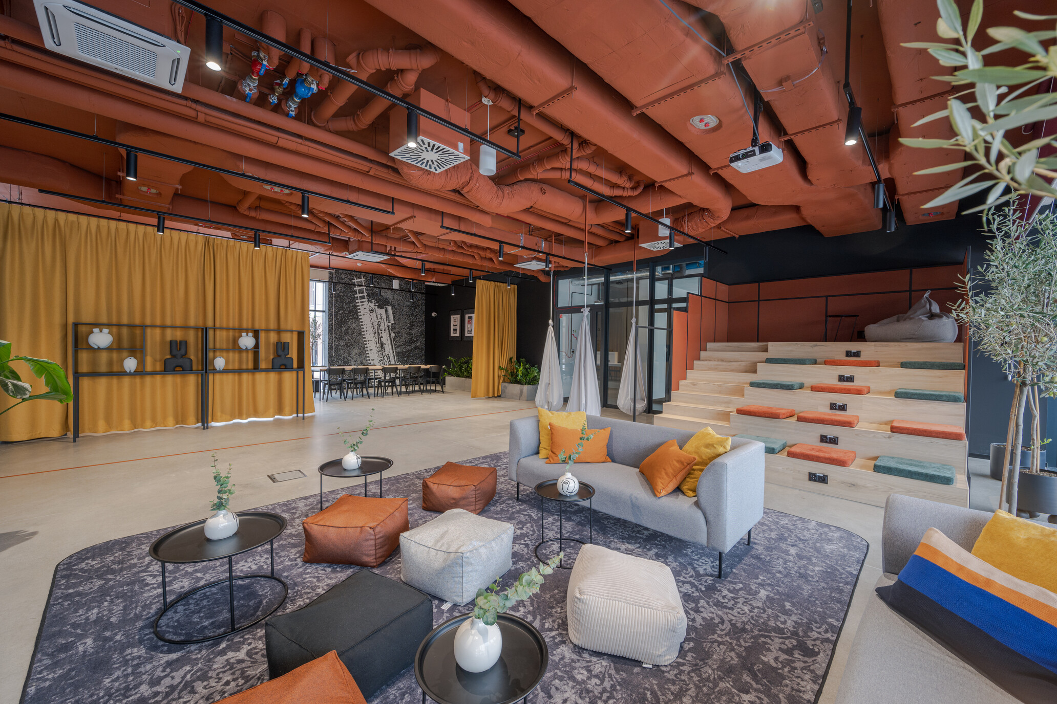 Open social area for students in Wrocław with colourful low seating, coffee tables and tiered benches.