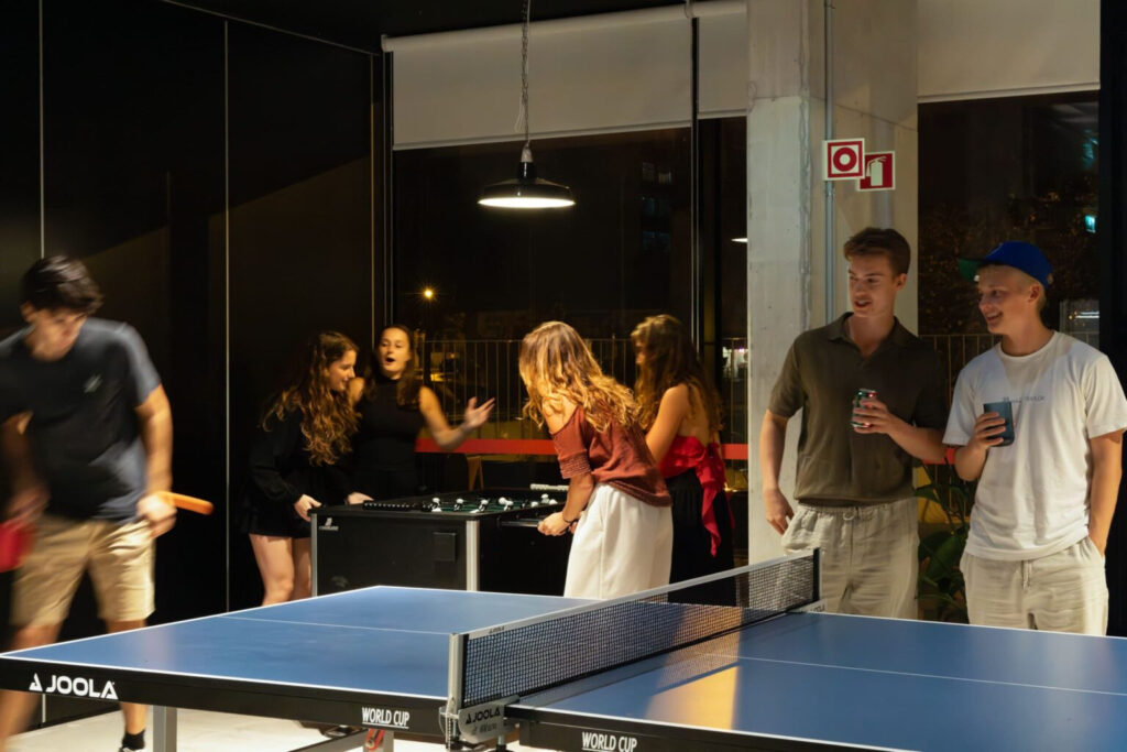 Fun evening at the Tribera Milan student accommodation, with students drinking an playing table tennis and foosball.