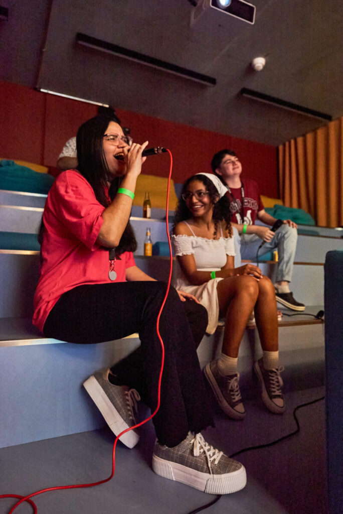 Students socializing and singing during a karaoke evening at the student accommodation in Milan.